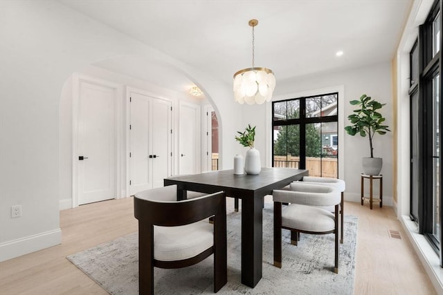 dining area with a chandelier and light hardwood / wood-style floors