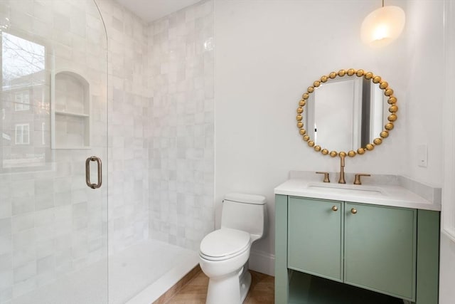 bathroom with vanity, a shower with door, and toilet