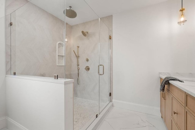 bathroom featuring a shower with door and vanity