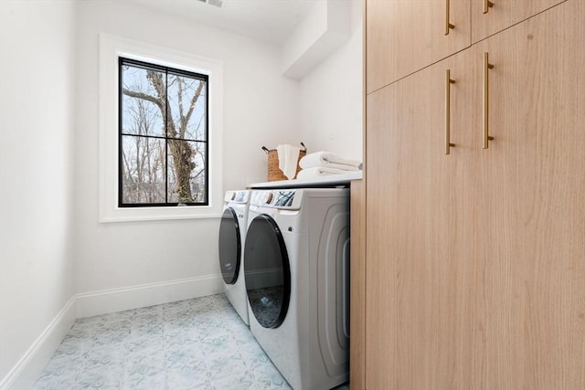 laundry room with washing machine and dryer and cabinets