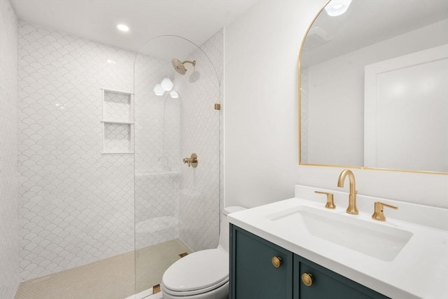 bathroom featuring vanity, toilet, and tiled shower