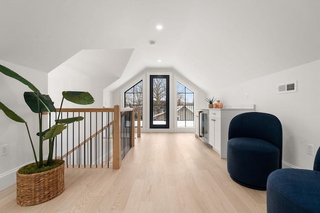 bonus room with wine cooler, lofted ceiling, and light hardwood / wood-style floors