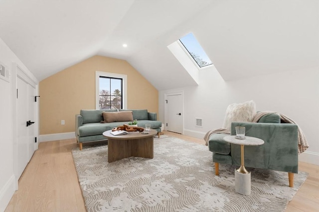 living area featuring lofted ceiling with skylight and light wood-type flooring