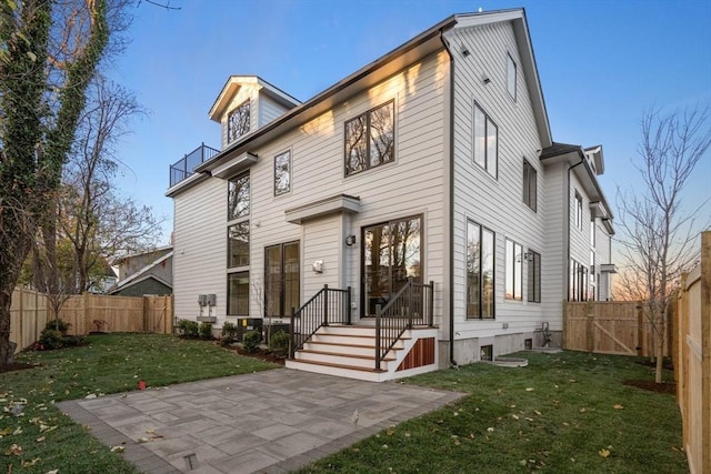 rear view of property with a patio area and a lawn