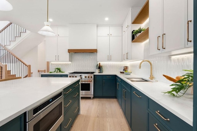 kitchen with white cabinetry, appliances with stainless steel finishes, sink, and decorative light fixtures