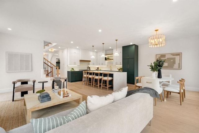 living room featuring a chandelier and light wood-type flooring