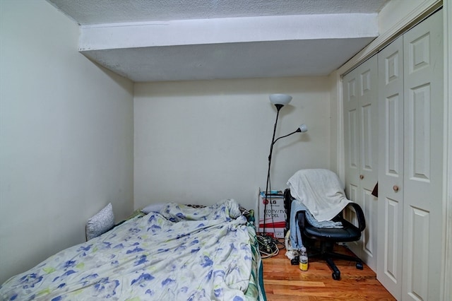 bedroom with wood-type flooring and a closet