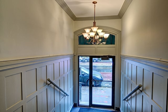 entrance foyer featuring ornamental molding and a notable chandelier