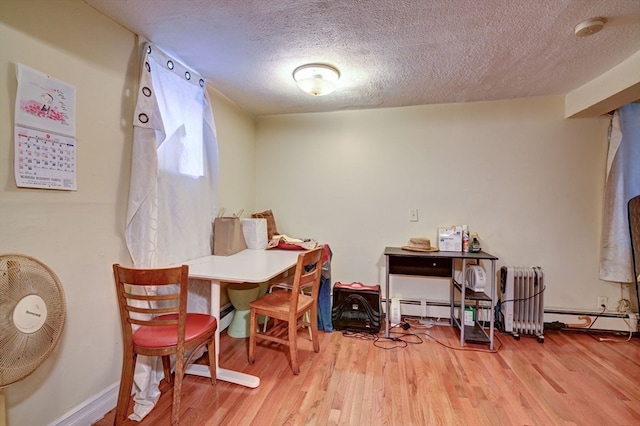 interior space with wood-type flooring, a textured ceiling, radiator, and baseboard heating