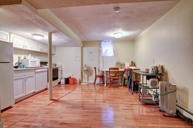 interior space featuring a baseboard heating unit, light wood-type flooring, a textured ceiling, and a fireplace