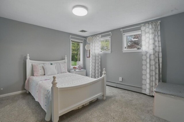 bedroom with a baseboard heating unit, carpet, and baseboards
