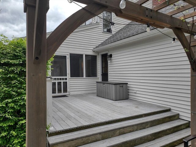 wooden terrace featuring a sunroom and a pergola