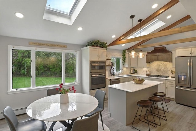 kitchen with stainless steel appliances, a skylight, light countertops, a breakfast bar, and decorative backsplash