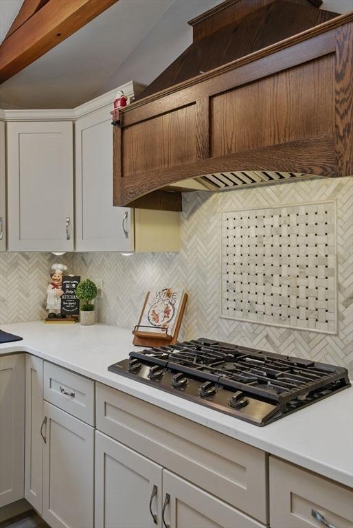 kitchen with gas stovetop, backsplash, and light countertops