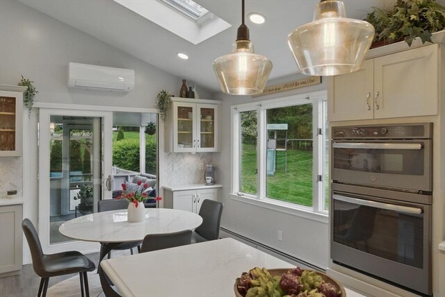 sunroom with an AC wall unit, a skylight, a baseboard radiator, and vaulted ceiling