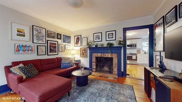 living room featuring ornamental molding, a brick fireplace, and light wood-type flooring