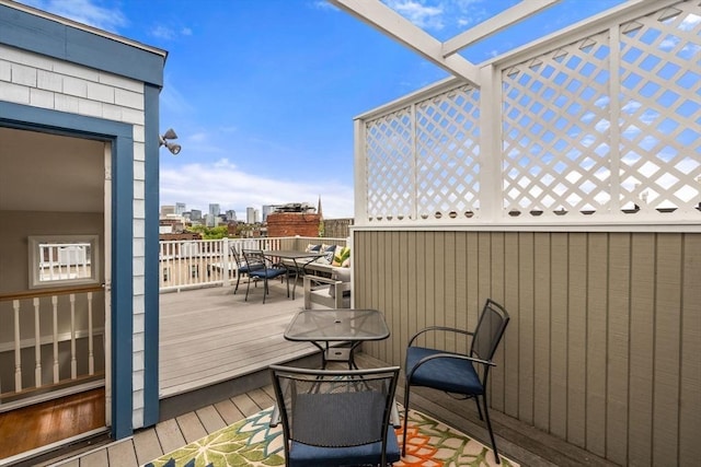 deck with outdoor dining space and a view of city