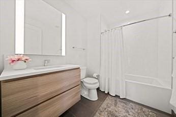 full bathroom featuring toilet, vanity, and shower / bathtub combination with curtain