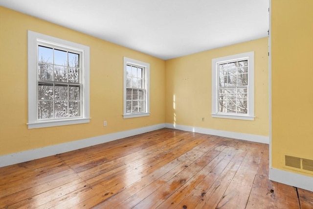 empty room featuring hardwood / wood-style floors and baseboards