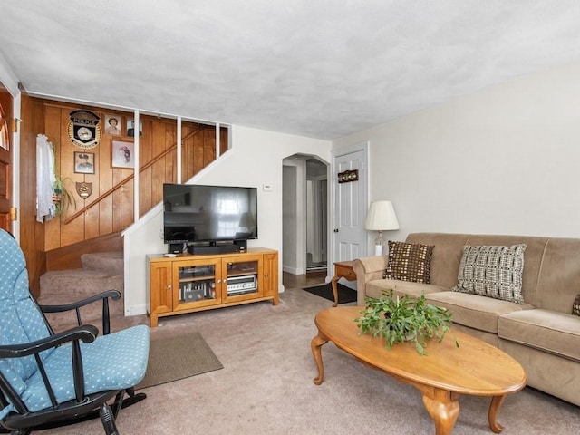 108 Edward Rd, Watertown, MA 02472 - carpeted living area with arched walkways, stairs, wooden walls, and baseboards