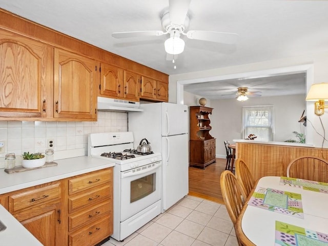 108 Edward Rd, Watertown, MA 02472 - kitchen with white gas range oven, ceiling fan, under cabinet range hood, light countertops, and backsplash