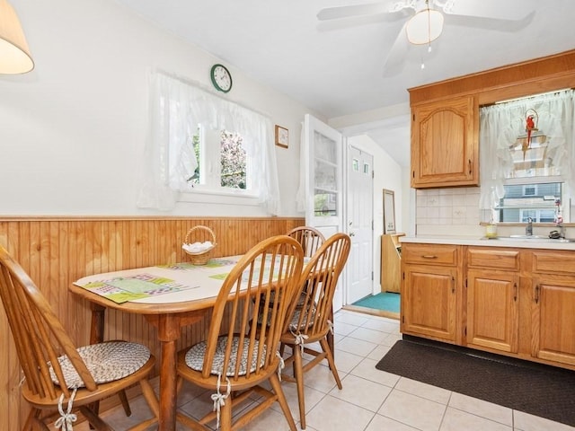 108 Edward Rd, Watertown, MA 02472 - dining area with wainscoting, light tile patterned floors, a ceiling fan, and wooden walls