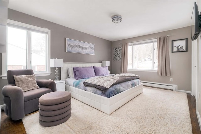 bedroom with baseboard heating and hardwood / wood-style flooring