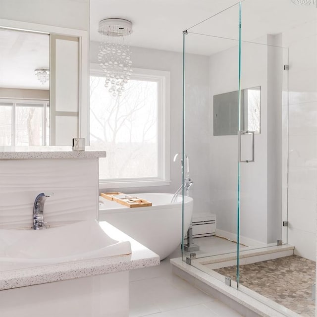 bathroom with baseboard heating, tile patterned flooring, a notable chandelier, and plenty of natural light