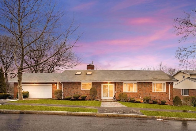 single story home with a garage and a lawn