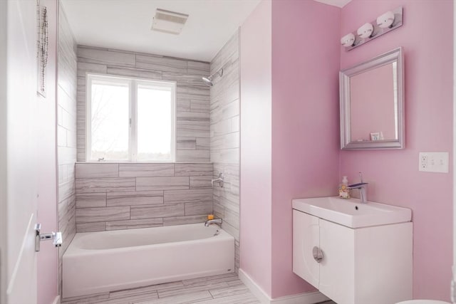 bathroom with tiled shower / bath and vanity