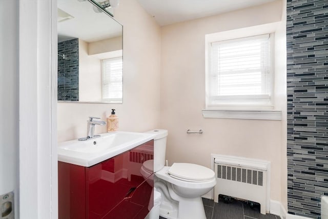 bathroom with toilet, a tile shower, tile patterned floors, radiator heating unit, and vanity