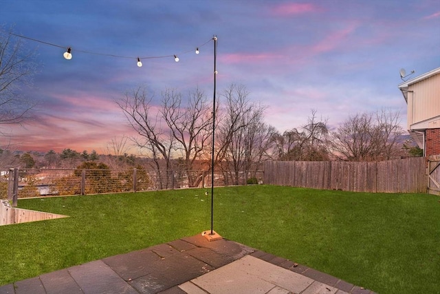 yard at dusk featuring a patio