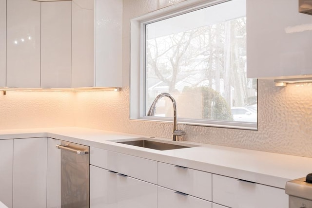 kitchen featuring plenty of natural light, white cabinets, and sink