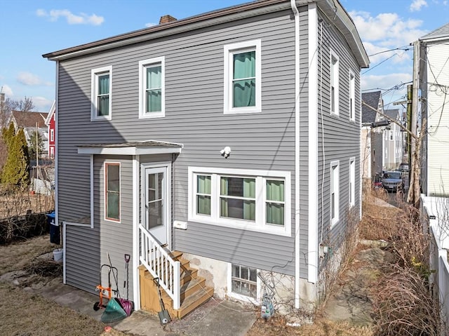 view of front of property featuring entry steps and a chimney