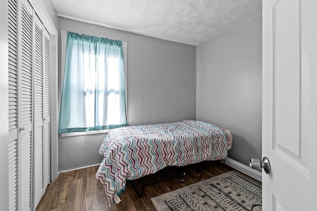 bedroom with baseboards and wood finished floors