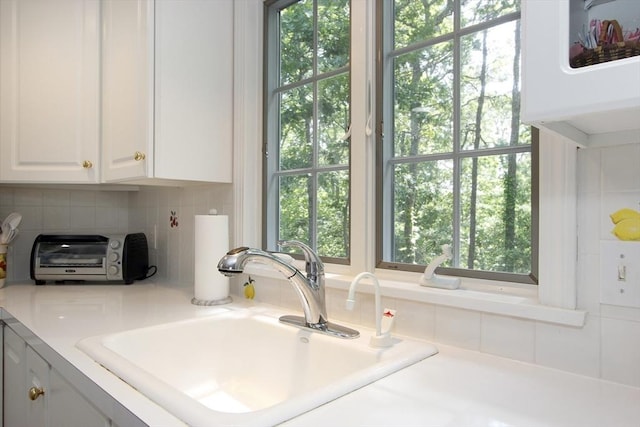 18 Periwinkle Ln, Mashpee, MA 02649 - kitchen featuring white cabinetry, light countertops, plenty of natural light, and backsplash
