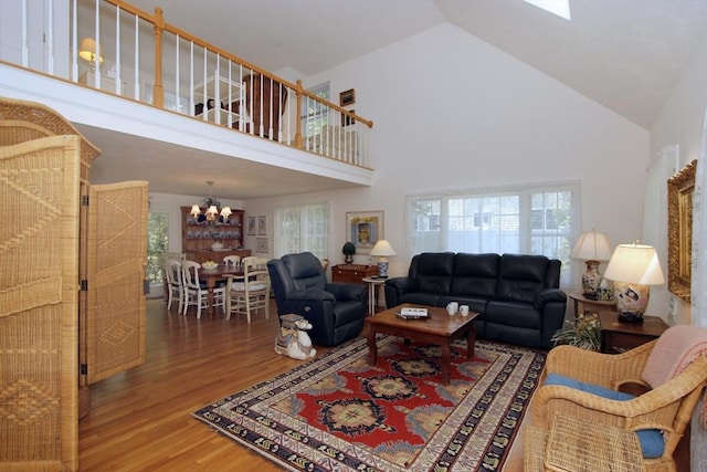 18 Periwinkle Ln, Mashpee, MA 02649 - living room with wood finished floors, high vaulted ceiling, a chandelier, and healthy amount of natural light