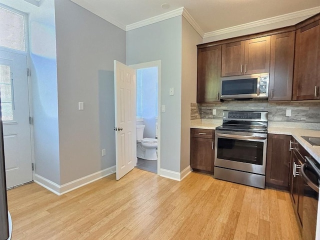 201 Thorndike St Unit 5-01, Lowell, MA 01852 - kitchen featuring stainless steel appliances, light wood-type flooring, crown molding, dark brown cabinets, and tasteful backsplash