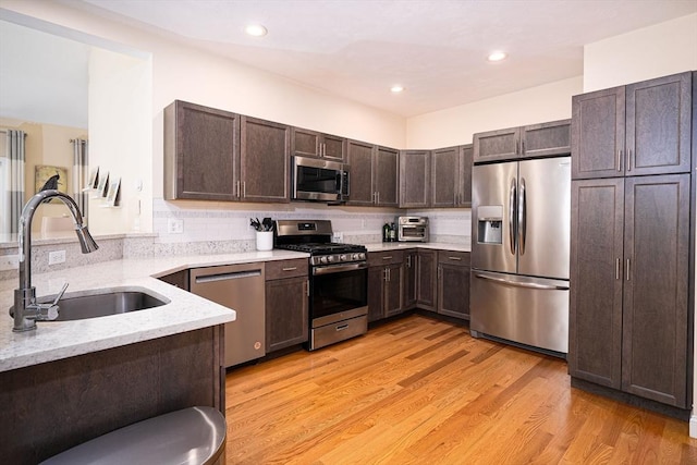 194 Crownshield Ave Unit 194, Uxbridge, MA 01569 - kitchen with appliances with stainless steel finishes, dark brown cabinets, decorative backsplash, light wood finished floors, and recessed lighting