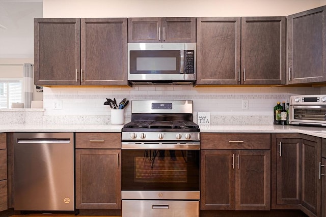 194 Crownshield Ave Unit 194, Uxbridge, MA 01569 - kitchen with stainless steel appliances, light countertops, tasteful backsplash, and dark brown cabinetry