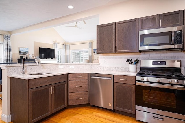 194 Crownshield Ave Unit 194, Uxbridge, MA 01569 - kitchen with appliances with stainless steel finishes, a peninsula, vaulted ceiling, a ceiling fan, and decorative backsplash
