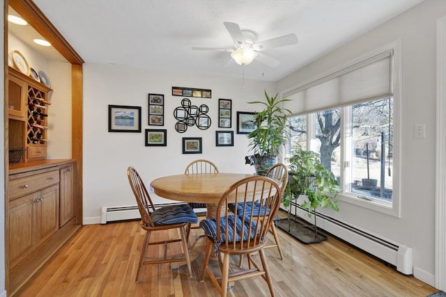 dining room featuring baseboards, light wood-type flooring, a baseboard heating unit, and ceiling fan