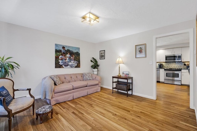 living area with baseboards and light wood finished floors