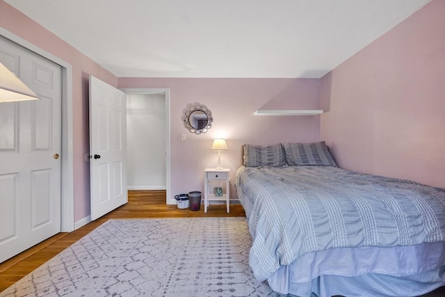 bedroom with baseboards and wood finished floors