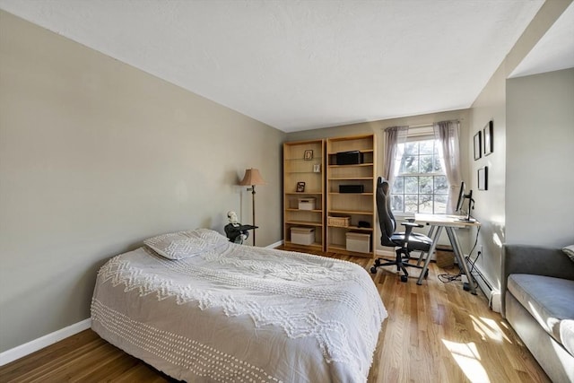 bedroom with baseboards and wood finished floors