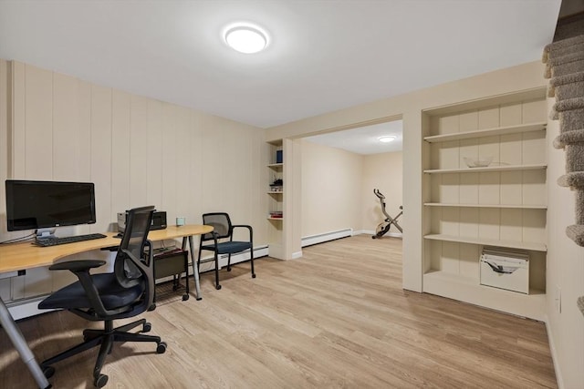 office space featuring built in features, a baseboard radiator, and light wood finished floors