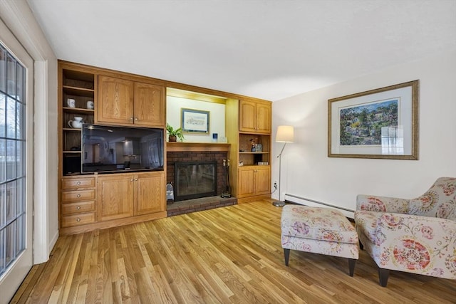 living room with baseboard heating, a brick fireplace, and light wood-type flooring