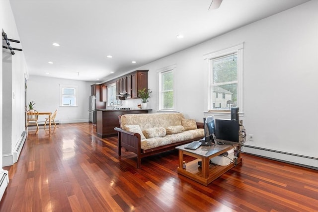 living room featuring baseboard heating, dark wood-style flooring, and recessed lighting