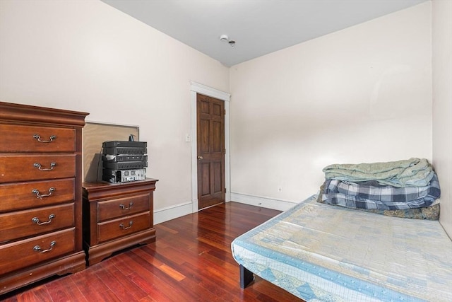 bedroom with dark wood-style flooring and baseboards