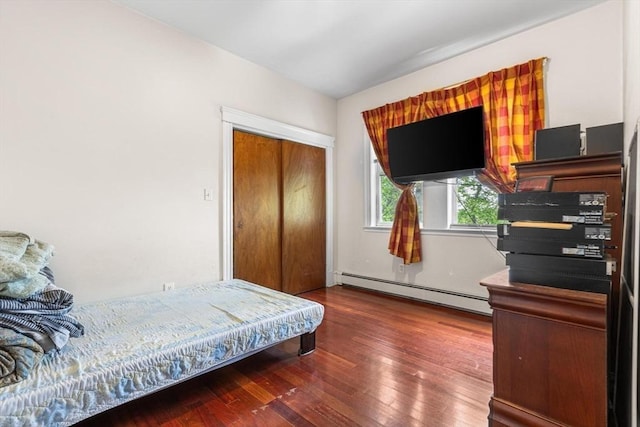 bedroom with a baseboard radiator and hardwood / wood-style floors